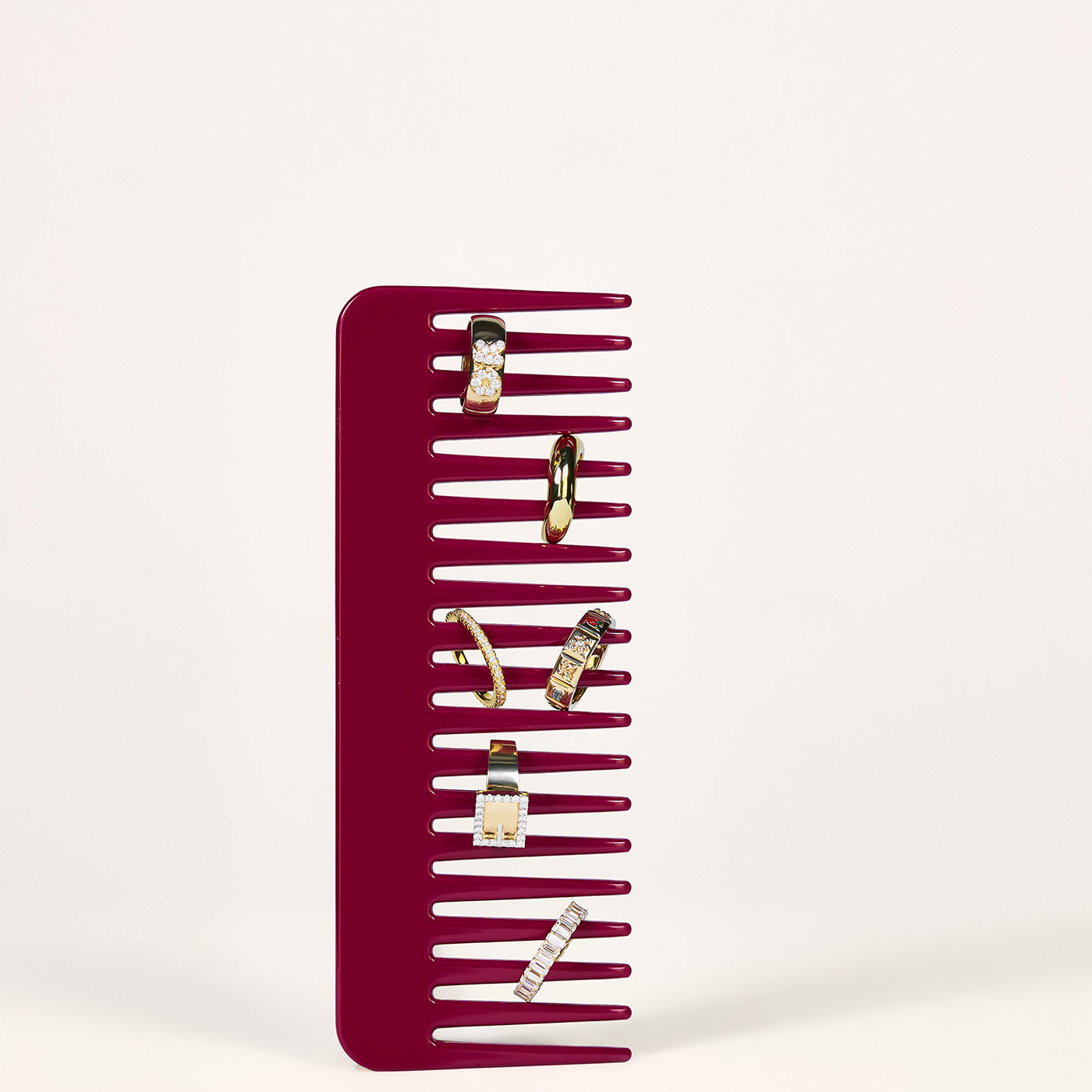 A burgundy red comb with 6 rings stacked on it.