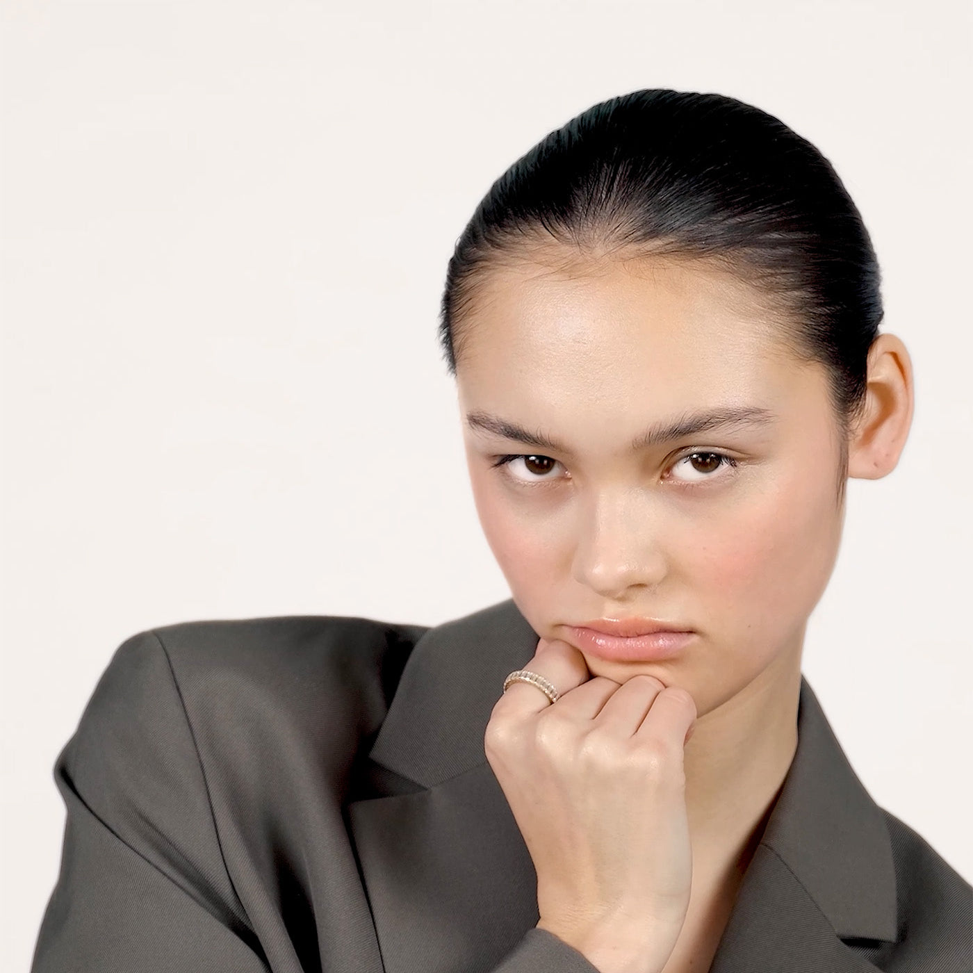 A video of a young woman wearing a sparkly moissanite eternity ring on her index finger.